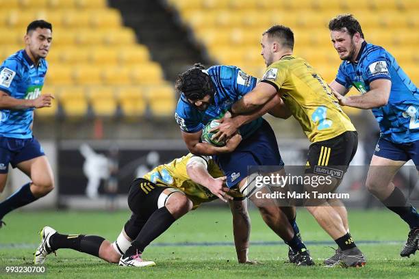 Ross White of the Blues is tackled during the round 18 Super Rugby match between the Hurricanes and the Blues at Westpac Stadium on July 7, 2018 in...