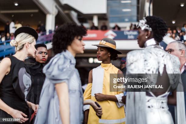 Women present creations by local designers during a fashion show at the 2018 editon of the Vodacom Durban July horse race in Durban, on July 6, 2018....