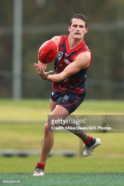 Harley Balic of the Demons handballs during the round 14 VFL match between Casey and North Melbourne at Casey Fields on July 7, 2018 in Melbourne,...