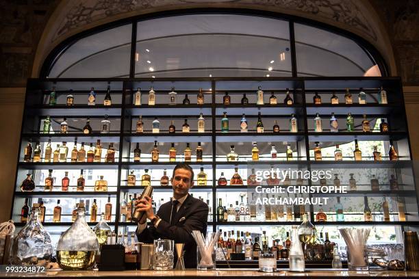 Bartender prepares a drink at the bar of the newly-refurbished Lutetia Hotel in Paris on July 6, 2018. - The iconic, history steeped Lutetia hotel,...