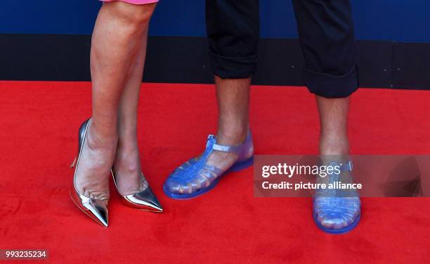 July 2018, Germany, Berlin: The footwear of Simone Thomalla, actress, and Silvio Heinevetter, handball player, pictured during the presentation by...