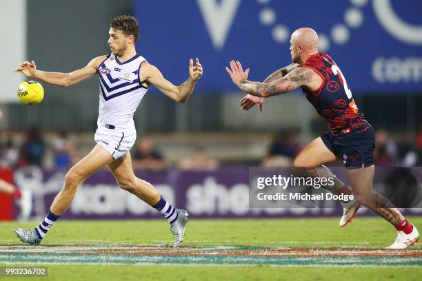 Tom Sheridan of the Dockers kicks the ball from Nathan Jones of the Demons during the round 16 AFL match between the Melbourne Demons and the...