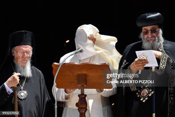 Gust of wind blows Pope Francis' cape as he delivers his speech next to Ecumenic Patriarch of the Orthodox Church Bartolomeo I and Egypt's Coptic...