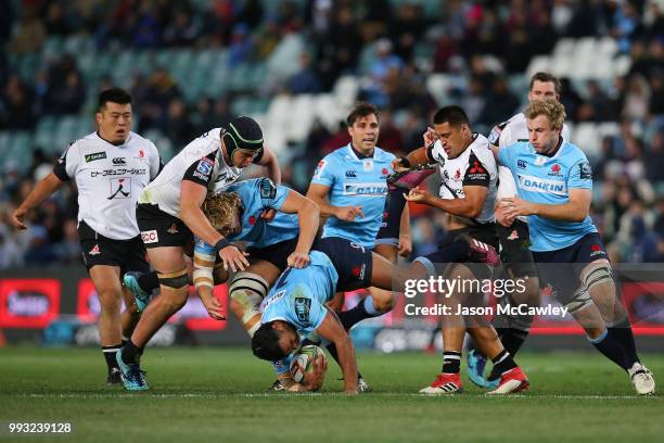 Kurtley Beale of the Waratahs is tackled during the round 18 Super Rugby match between the Waratahs and the Sunwolves at Allianz Stadium on July 7,...