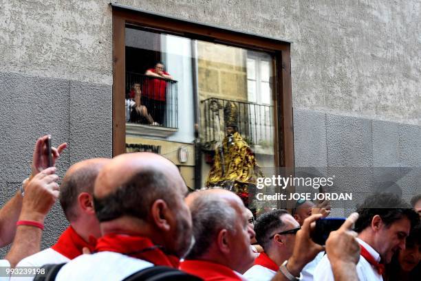 People attend the procession of Pamplona´s patron Saint Fermin on the first day of the San Fermin bull run festival in Pamplona, northern Spain on...