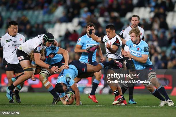 Kurtley Beale of the Waratahs is tackled during the round 18 Super Rugby match between the Waratahs and the Sunwolves at Allianz Stadium on July 7,...