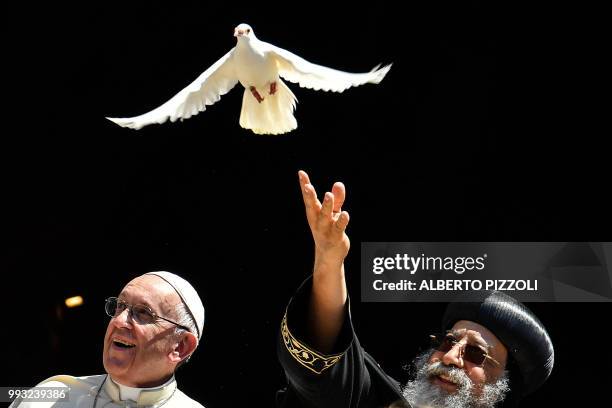 Pope Francis watches as Egypt's Coptic Orthodox Pope Tawadros II releases a dove after a meeting with other religious leaders at the Pontifical...