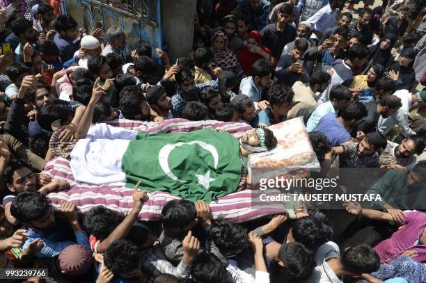 Graphic content / Kashmiri villagers carry a body of a youth Shakir during a funeral procession at Kulgam, south of Srinagar on July 7, 2018. -...