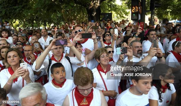 People take pictures during the procession of Pamplona´s patron Saint Fermin on the first day of the San Fermin bull run festival in Pamplona,...