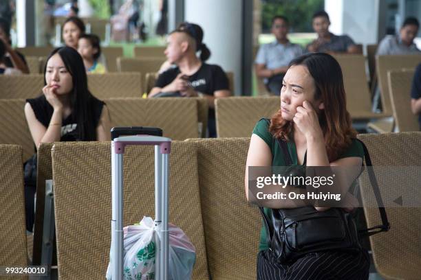 Family members of passengers onboard a capsized tourist boat wait at Phuket Airport upon their arrival on July 7, 2018 in Phuket, Thailand. At least...