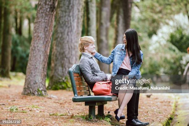 amoureux de s’asseoir sur un banc et passer moment intime dans un parc de verdure fraîche - sasseoir photos et images de collection