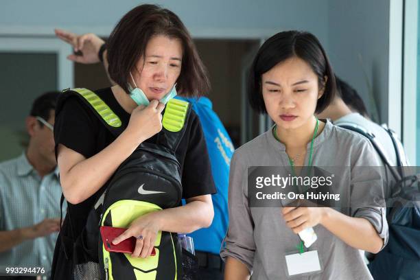 Family member of a passenger onboard a capsized tourist boat, accompanied by a volunteer translator, exits a room after identification process at the...