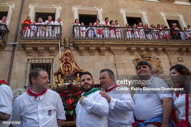 Revellers stand next to a figure of San Fermin during the San Fermin procession on the second day of the San Fermin Running of the Bulls festival on...