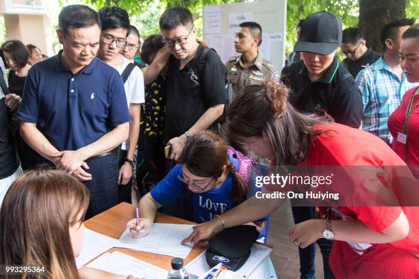 Family members of passengers onboard a capsized tourist boat carry out registration upon their arrival at the Vachira Phuket Hospital on July 7, 2018...