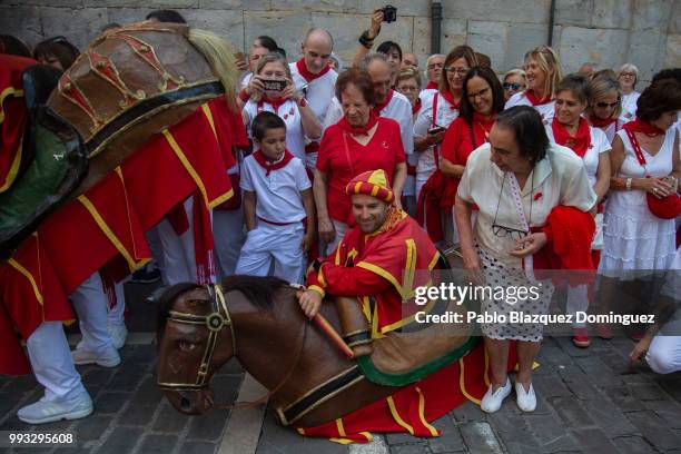 Woman pretends to sit on the back of a 'Zaldiko' during the Comparsa de Gigantes y Cabezudos, or Giants and Big Heads parade on the second day of the...