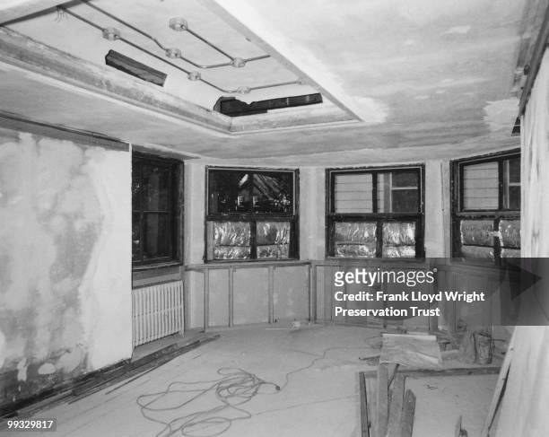 Dining room restoration in progress with tile floor removed, bare plaster on walls, and the built-in not yet installed, at the Frank Lloyd Wright...