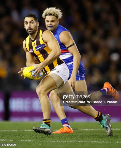 Paul Puopolo of the Hawks is chased by Jason Johannisen of the Bulldogs during the 2018 AFL round 16 match between the Western Bulldogs and the...