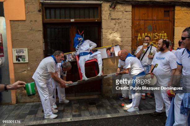 Revellers of 'la Jarana' carry along the streets a figure of a friend on the second day of the San Fermin Running of the Bulls festival on July 7,...