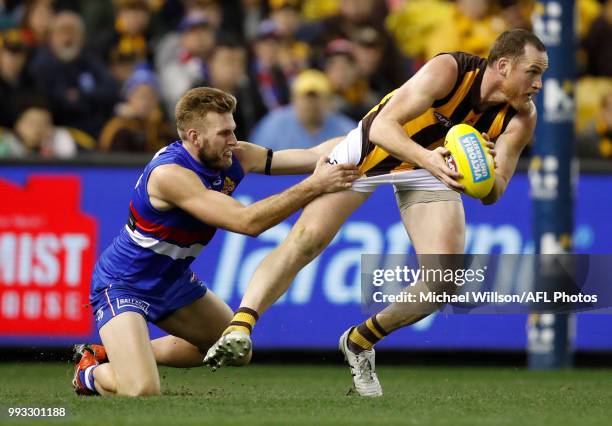 Jarryd Roughead of the Hawks is tackled by Jackson Trengove of the Bulldogs during the 2018 AFL round 16 match between the Western Bulldogs and the...