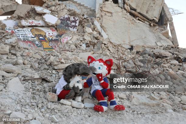 Two Syrian activists wearing the cat and wolf Russia 2018 World Cup mascot's outfits perform during an event to protest against the bombings in...