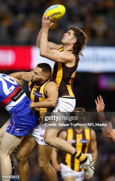 Ben Stratton of the Hawks takes a big mark over Jarman Impey of the Hawks during the 2018 AFL round 16 match between the Western Bulldogs and the...