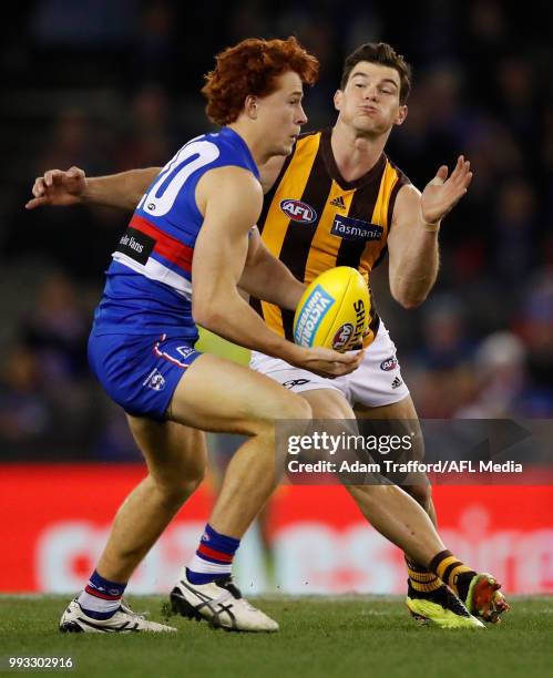 Ed Richards of the Bulldogs is tackled by Jaeger O'Meara of the Hawks during the 2018 AFL round 16 match between the Western Bulldogs and the...