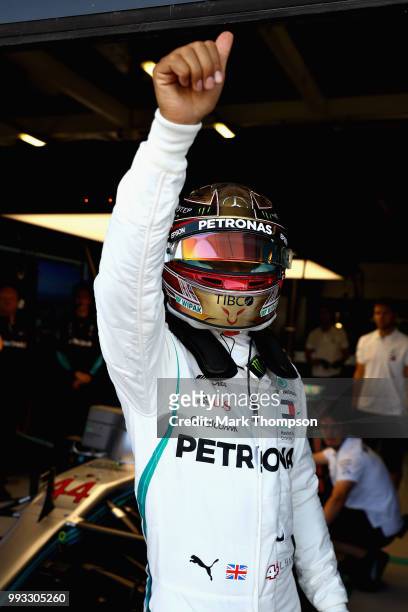 Lewis Hamilton of Great Britain and Mercedes GP waves to the crowd from his garage during qualifying for the Formula One Grand Prix of Great Britain...