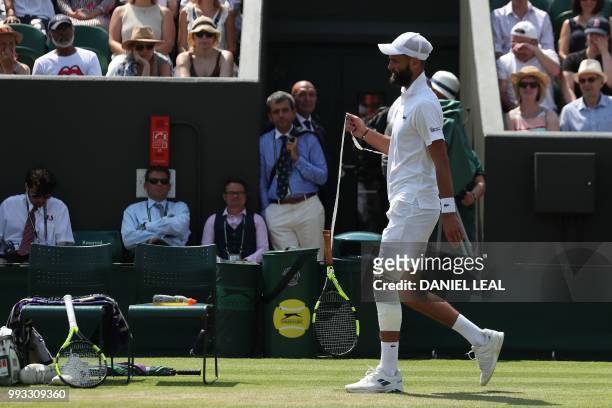 France's Benoit Paire changes his racked while playing Argentina's Juan Martin del Potro in their men's singles third round match on the sixth day of...