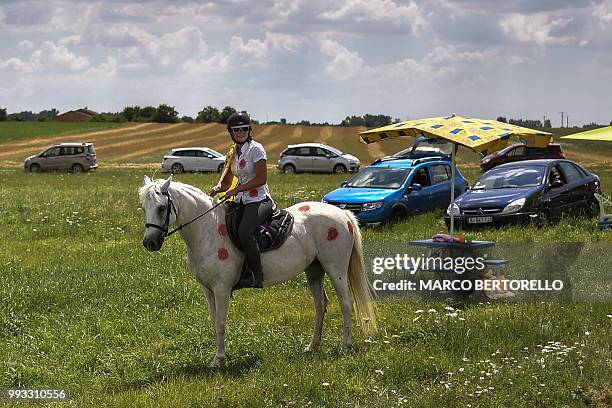 Woman on horseback waits to watch riders during the first stage of the 105th edition of the Tour de France cycling race between Noirmoutier-en-l'ile...