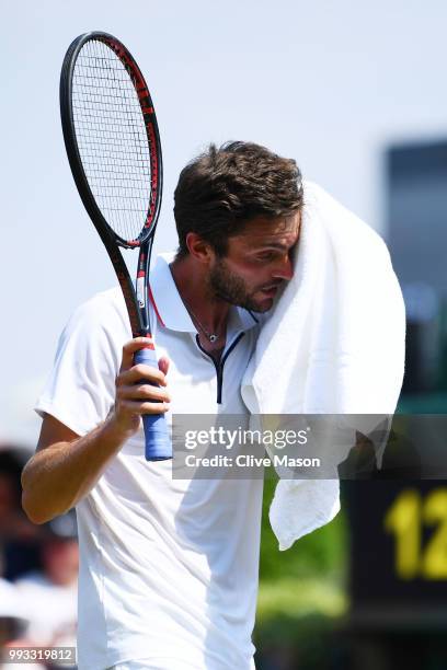 Gilles Simon of France towels down against Matthew Ebden of Australia during their Men's Singles third round match on day six of the Wimbledon Lawn...