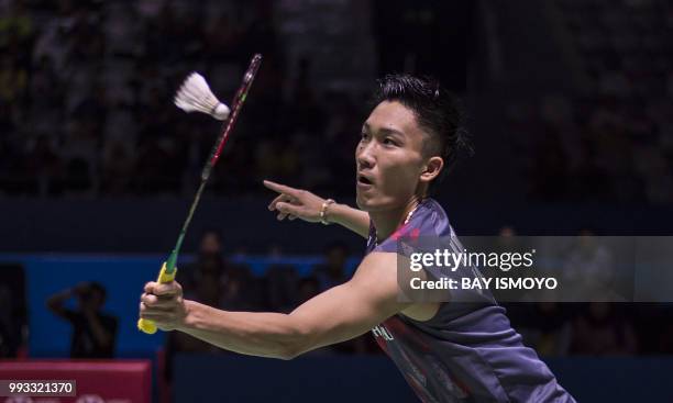 Kento Momota of Japan hits a return against Lee Chong Wei of Malaysia during their men singles semi-final match at the Indonesia Open badminton...