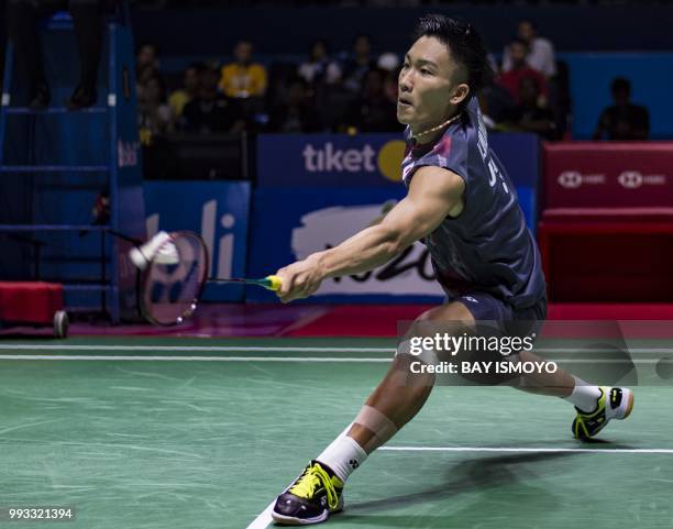 Kento Momota of Japan hits a return against Lee Chong Wei of Malaysia during their men singles semi-final match at the Indonesia Open badminton...