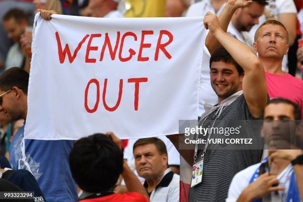An England fan holds a banner referring to Arsenal's French coach Arsen Wenger before the Russia 2018 World Cup quarter-final football match between...