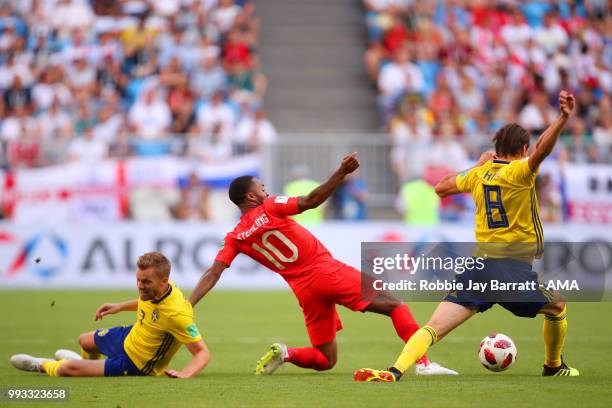 Raheem Sterling of England competes with Albin Ekdal and Sebastian Larsson of Sweden during the 2018 FIFA World Cup Russia Quarter Final match...