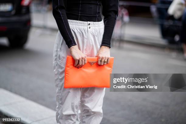 Caroline Daur wearing orange Prada clutch, black turtleneck, Prada heels, white track suit pants is seen outside Viktor & Rolf on day four during...