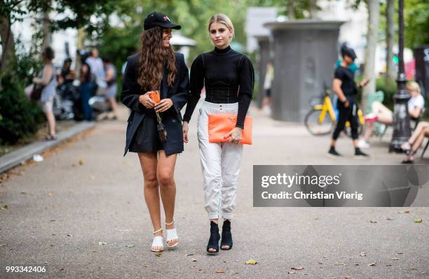 Erika Boldrin wearing Diesel cap Hate Couture, mini Louis Vuitton bag and Caroline Daur wearing orange Prada clutch, black turtleneck, Prada heels,...