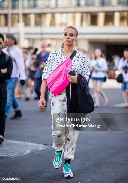 Model Adwoa Aboah wearing white button shirt with Playboy print, Nike pants, pink Prada belt bag, sneakers seen outside Fendi Couture on day four...