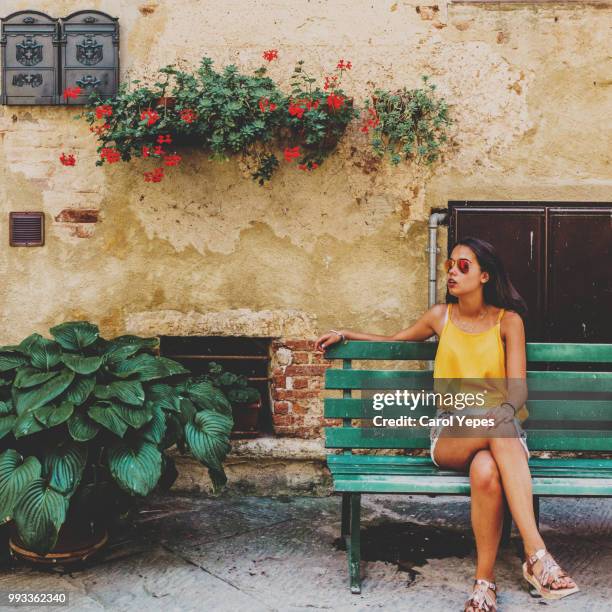 young brunette woman sitting on green bench on siena,tuscany,italy - siena italy stock pictures, royalty-free photos & images