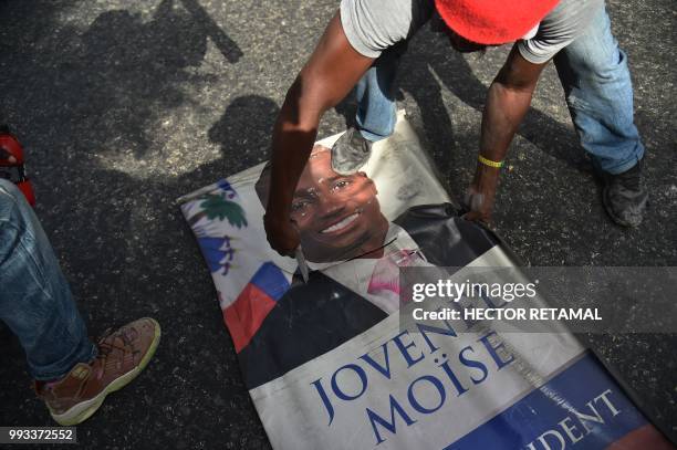 Protesters destroy a poster of Haitian President Jovenel Moise as they demonstrate in the Port-au-Prince suburb of Petion-Ville on July 7 against a...