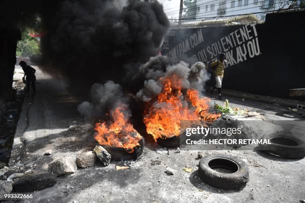 Tires burn at a barricade placed by demonstrators on the streets of the Port-au-Prince suburb of Petion-Ville on July 7 to protest against the...