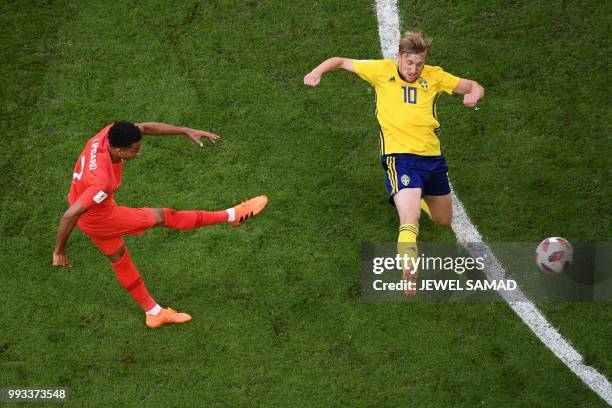 England's midfielder Jesse Lingard attempts a shot as he is marked by Sweden's midfielder Emil Forsberg during the Russia 2018 World Cup...