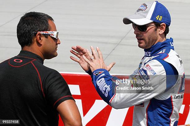 Jimmie Johnson , driver of the Lowe's Chevrolet, talks with Juan Pablo Montoya, driver of the Target Chevrolet, on the grid during qualifying for the...