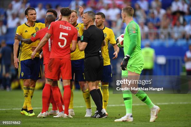 Referee Bjorn Kuipers separates Jordan Pickford of England and Marcus Berg of Sweden during the 2018 FIFA World Cup Russia Quarter Final match...