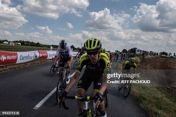Great Britain's Christopher Froome is overtaken by Spain's Mikel Nieve and other riders as he gets going again after falling in the last kilometers...