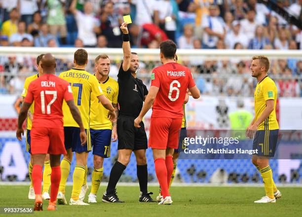 Referee Bjorn Kuipers shows Harry Maguire of England a yellow card during the 2018 FIFA World Cup Russia Quarter Final match between Sweden and...
