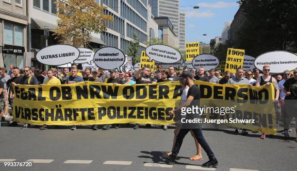 Ultras of Borussia Dortmund march amongst other protesters to denounce a new law that would give police more powers on July 7, 2018 in Dusseldorf,...