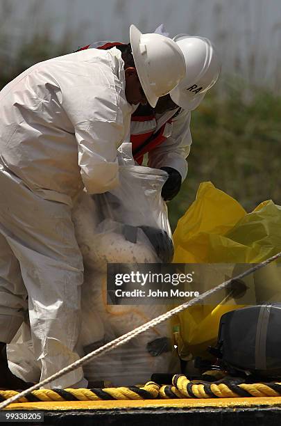 Oil spill cleanup workers pack up oil-absorbent booms for disposal at South Pass near the mouth of the Mississippi River on May 14, 2010 near Venice,...