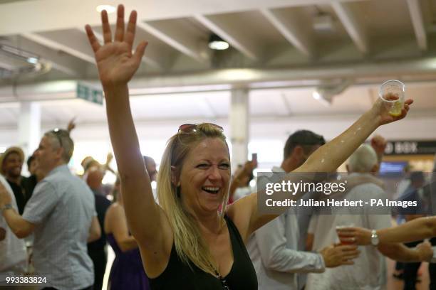 Racegoers watch the FIFA World Cup quarter final between England and Sweden during Coral Eclipse day at Sandown Park Racecourse, Esher.