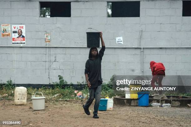 Boy fetches water at a communal tap in Maglass township close to where Movement for Democratic Change Alliance supporters were addressed by...