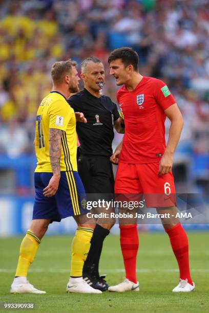 Referee Bjorn Kuipers separates John Guidetti of Sweden and Harry Maguire of England during the 2018 FIFA World Cup Russia Quarter Final match...